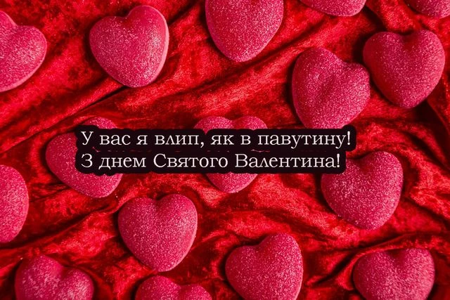 Розові серця на червоній тканині з привітанням.