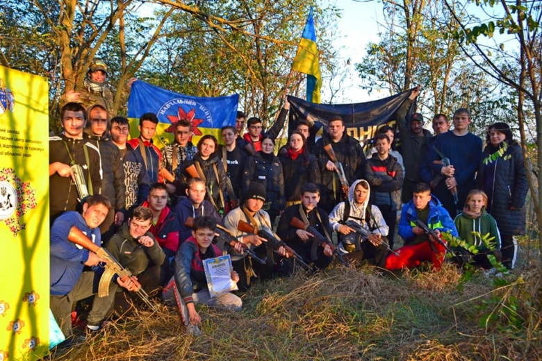 Група української молоді з прапорами та зброєю на патріотичному заході