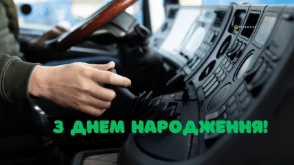 Водій у кабіні вантажівки з привітанням на день народження українською.