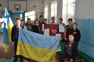 Група молоді з прапорами та плакатами під час патріотичної події