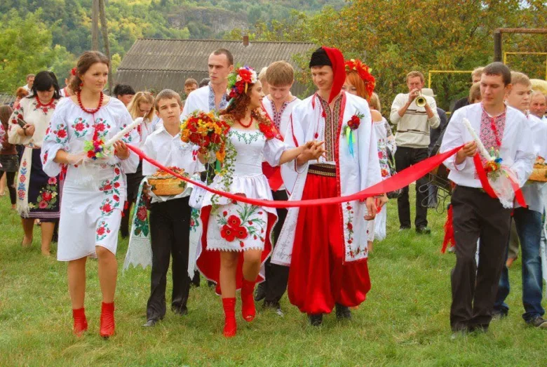 Українське весілля: наречена в вишиванці йде з квітами.