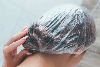 Голова підлітка в плівці після нанесення шампуню