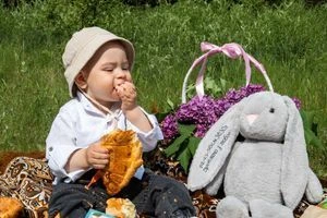 Дитина на хрестині з їжею та іграшковою кроликом