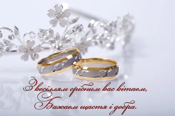 Золоті кільця та тиара на фоні з привітанням до весілля