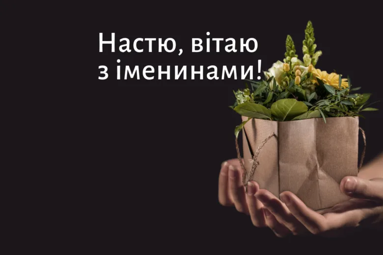 Руки тримають паперову сумку з квітами на чорному фоні.